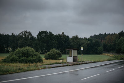 Wet road against trees during rainy season