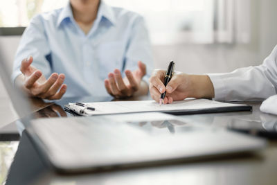 Midsection of businessman working at desk in office