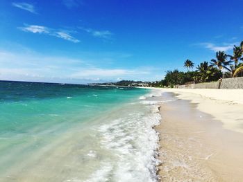 Scenic view of beach against blue sky