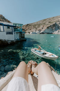 Low section of woman sitting near sea