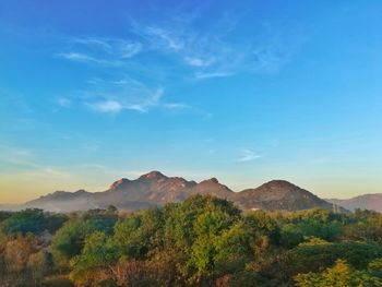 Scenic view of mountains against blue sky