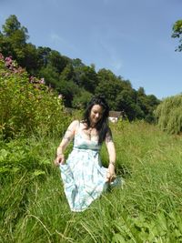 Portrait of young woman standing on grass