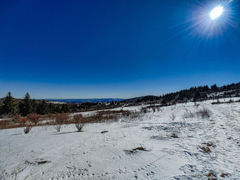 Scenic view of snowcapped mountains against clear blue sky