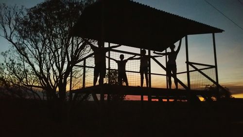 Low angle view of silhouette tower against sky at sunset