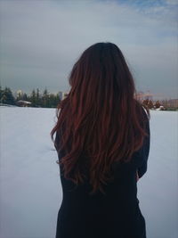 Rear view of woman on snow covered field