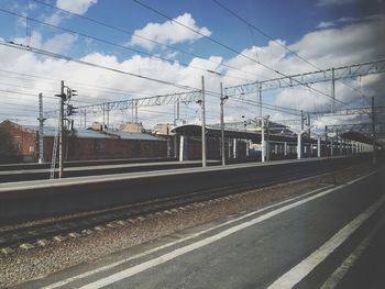 Railroad tracks against cloudy sky