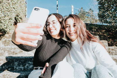 Young female friends taking selfie outdoors