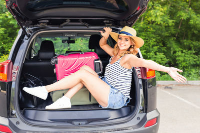 Portrait of smiling young woman sitting in car