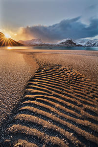 Scenic view of arid landscape against sky during sunset