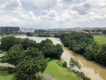 River amidst trees and buildings in city against sky