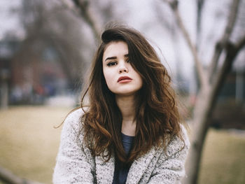 Portrait of beautiful young woman standing at park