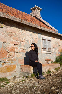 Side view of man standing against old building