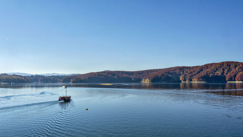 Scenic view of lake against clear blue sky