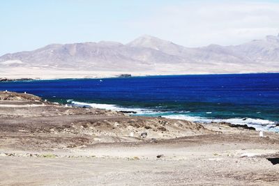 Scenic view of sea and mountains against sky