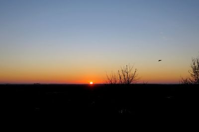 Silhouette landscape against clear sky during sunset