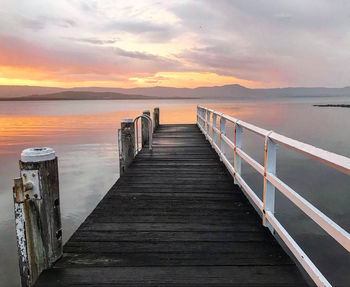 Wooden pier on sea against sky during sunset