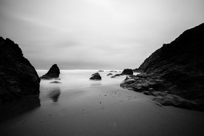 Rocks on beach against sky