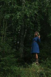 Woman standing on field in forest