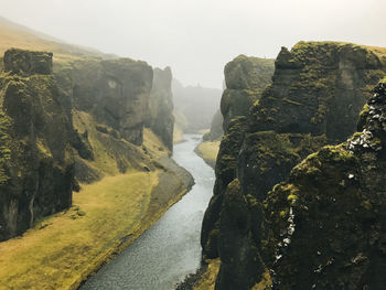 Scenic view of river amidst mountains against sky