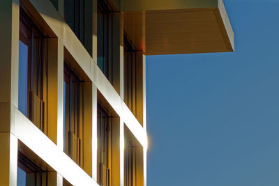 Low angle view of modern building against clear blue sky