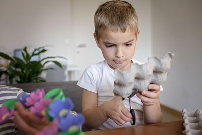 Kids create easter flower wreath in pastel colors using an upcycled egg trail. zero waste lifestyle