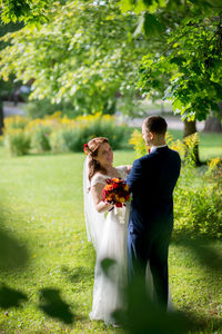 Young couple holding flower in garden