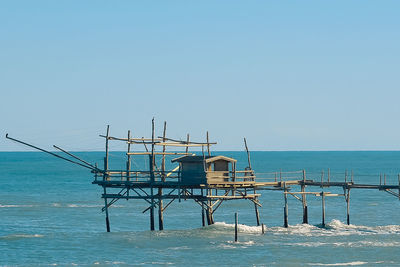 Lifeguard hut on beach against clear blue sky