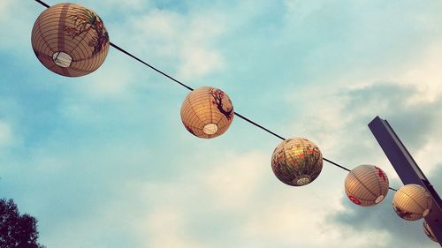 Low angle view of lanterns hanging against sky