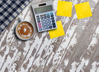 High angle view of coffee and calculator on table