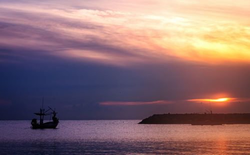 Silhouette boat in sea against sky during sunset