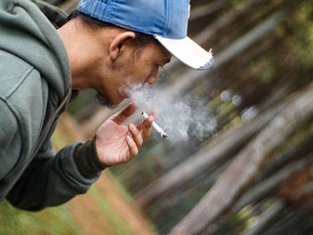 The view of a man smoking in the middle of the forest