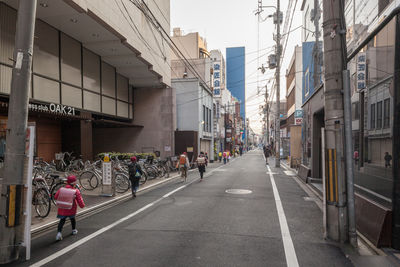 People on street amidst buildings in city