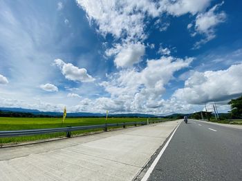 Empty road against cloudy sky