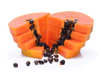 Close-up of stacked papaya slices against white background