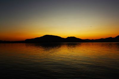 Scenic view of lake against orange sky