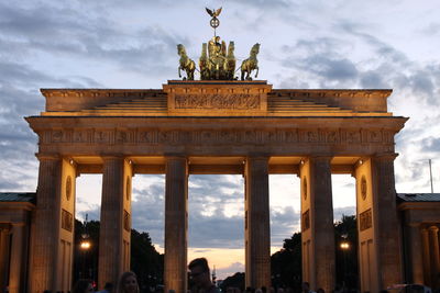 Low angle view of brandenburg gate against cloudy sky