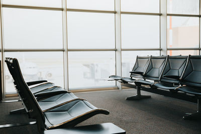 Empty chairs and tables in glass window