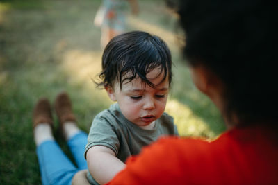 Close-up of mother and son sitting outdoors