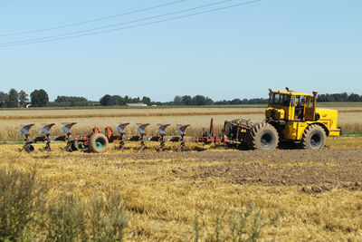 Tractor on field against clear sky