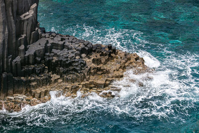 High angle view of waves splashing on rocks