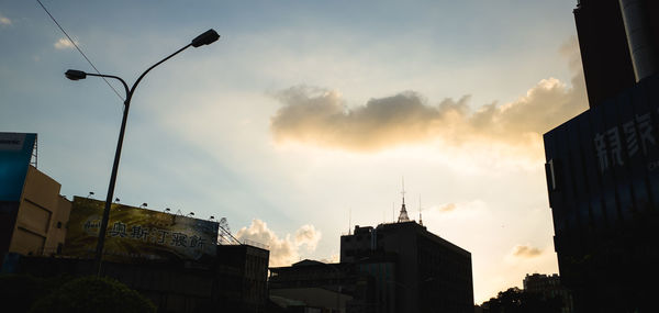 Low angle view of buildings against cloudy sky