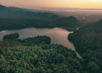 Scenic view of lake and mountains against sky during sunset