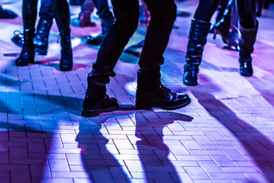 Low section of people dancing on illuminated floor
