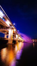 Suspension bridge over river at night