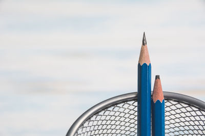 Close-up of multi colored pencils against blue sky