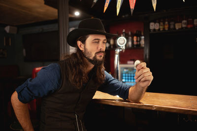 Portrait of young man standing in bar