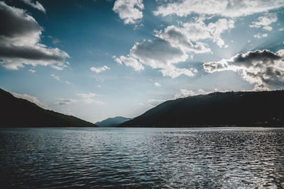 Scenic view of lake by mountains against sky