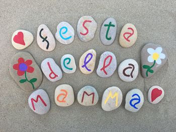 High angle view of multi colored pebbles with text at beach