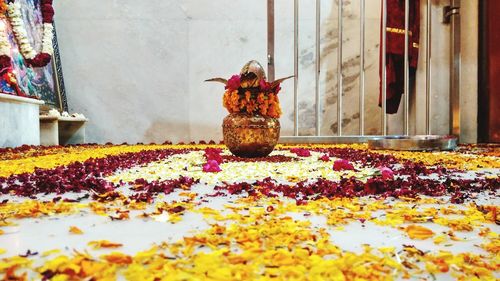 Decorated kalash on petals covered floor at home