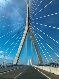 Low angle view of suspension bridge against sky